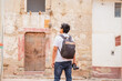young latin male traveler photographer exploring ancient city and taking pictures with camera