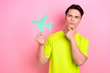 Poster - Photo of doubtful unsure man dressed yellow t-shirt rising plane looking empty space isolated pink color background