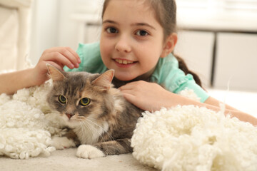 Wall Mural - Cute little girl with cat lying on carpet at home. First pet