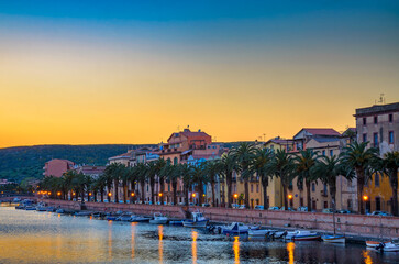 Wall Mural - Sunset over Bosa with palm trees and colorful buildings along the Temo River in Sardinia, Italy