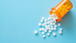 White pills in an orange bottle on a blue background.