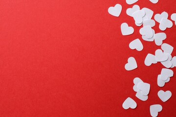 Wall Mural - White paper hearts on red background, flat lay. Space for text