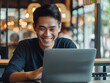 © DS Showcase - A young Indonesian male in his 20s looking at his laptop screen with a smile and joy