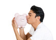 © pathdoc - young man giving a kiss to a piggy bank