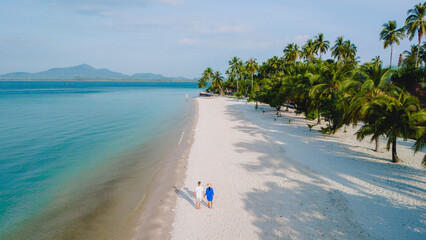 Wall Mural - Koh Mook Drone view at a couple walking on the white sandy tropical beach of Koh MukThailand