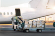 © Kirill Gorlov - Close-up detail view of cargo cart trolley full with commercial parcels against turboprop cargo plane. Air mail shipping and logistics. Import export operations. Commercial charter flight service