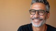 © iuricazac - Smiling man with gray hair and beard wearing black glasses in a black shirt against a warm-toned background.