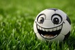 A happy cartoon soccer ball with big eyes rests on the thick green grass