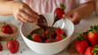 A child dipping strawberries into a bowl of melted chocolate, creating a delicious and interactive snack