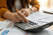 © Marcelo - Accountant professional working on desk using calculator and analyzing financial report papers