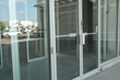 © Penguin - generic glass store doors and windows front entrance with reflection of parking lot and sky