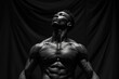 Monochrome image of a muscular man looking upwards with a dramatic black backdrop, highlighting strength and determination.