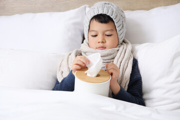 Poster - Ill little Asian boy taking tissue from box in bedroom