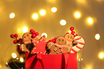 Wall Mural - Shopping bag with Christmas gingerbread cookies and rowan on blurred lights background