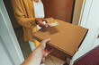 © M-Production - Man delivering pizza in box and taking payment.