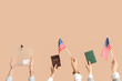 © Pixel-Shot - Hands holding ballot box, passports and USA flags on beige background. Election concept
