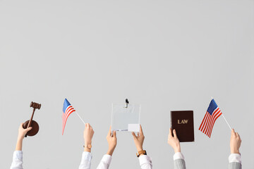 Wall Mural - Hands holding ballot box, law book, USA flags and judge's gavel on white background. Election concept