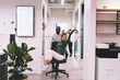 © BullRun - Funny diverse coworkers rolling woman on office chair