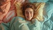 © Татьяна Креминская - An overhead view of a smiling woman lying in bed, covered with a pastel color blanket