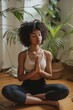 © Artsaba Family - A woman practices meditation in a serene indoor setting surrounded by lush green plants.