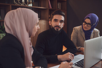 Wall Mural - Business team of a two Muslim woman and man working together in the office.