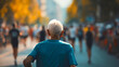 © Nemanja - Rearview photography of a senior old man with gray hair wearing a blue t shirt and running a marathon race event. Elderly male person competing in endurance running outdoors, sunny day exercise