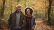 © Annemarie - afro american elderly senior couple walking together in autumnal forest. retirement enjoying