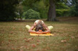 © Natalje Dietrich - A middle-aged woman is doing yoga in the park