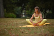© Natalje Dietrich - A middle-aged woman is doing yoga in the park