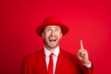 Poster - Photo portrait of attractive young man point up look empty space excited dressed stylish classic clothes isolated on red color background