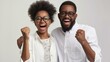 © Lakkhana - African American man and woman happy for win, excited ethnic couple in spectacles feel overjoyed receiving good news being successful isolated on grey studio background