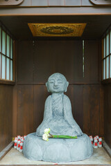 Wall Mural - Buddha statue in a peaceful temple, surrounded by serene white stone, embodying Asian culture and spirituality