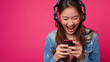 © wiparat - Young woman wearing headset and playing online game on smartphone