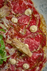 Wall Mural - Italian carpaccio with artichokes, arugula in a plate. A delicious snack