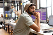 © Wavebreak Media - Young Asian man ponders at his casual business office desk