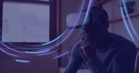 Wall Mural - Image of glowing light trails of data transfer over african american man in vr headset