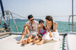 © Kawee - Asian happy family sitting on deck of yacht while yachting outdoor.