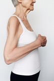 Fototapeta  - cropped shot of an unrecognizable woman measuring her arms against a white background