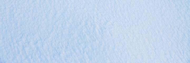 Wall Mural - Natural snow texture. Smooth surface of clean fresh snow. Snowy ground. Winter background with snow patterns. Closeup top view. Wide panoramic texture for background and design.