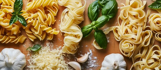 Wall Mural - Close up view of various Italian pasta types, fresh basil, and garlic on a wooden cutting board.