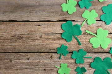 St. Patrick's day. Decorative clover leaves on wooden background, flat lay. Space for text