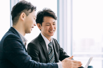 Poster - パソコンを見て話す2人の男性ビジネスマン