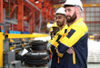 © Nassorn - Group of people wear safety helmet uniform standing together in factory. Engineer technician team in hardhat working in manufacturing. Multicultural colleague caucasian latin men in steel production.