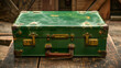 An old vintage-style travel suitcase with a shabby green appearance and brass fittings on wooden floor