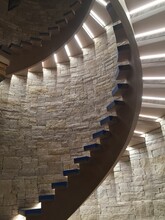 Interior Shot Of A Stone Wall Featuring A Staircase With Illuminated Spiral Steps