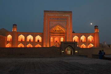 Wall Mural - The ancient Allakuli Khan madrasah in orange illumination on the late evening, Khiva