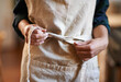 © Jeff Bergen/peopleimages.com - Hands, chef and tie apron in kitchen, restaurant or catering service at hotel for gastronomy. Closeup, cooking or person with knot on clothes, culinary uniform or preparation of professional waitress