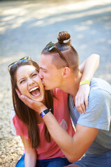 Poster - Love, kiss and happy couple in a park for travel, bonding and having fun on date in nature together. Smile, face and people embrace while chilling in a forest with romance, support and adventure