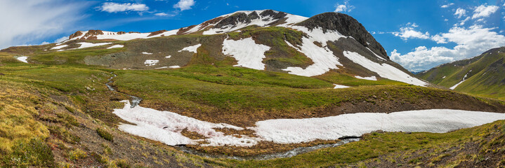 Wall Mural - mountain panorama with stream and snow patches 