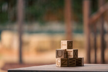 Stack of wooden building blocks with letters on blurred background with copy space